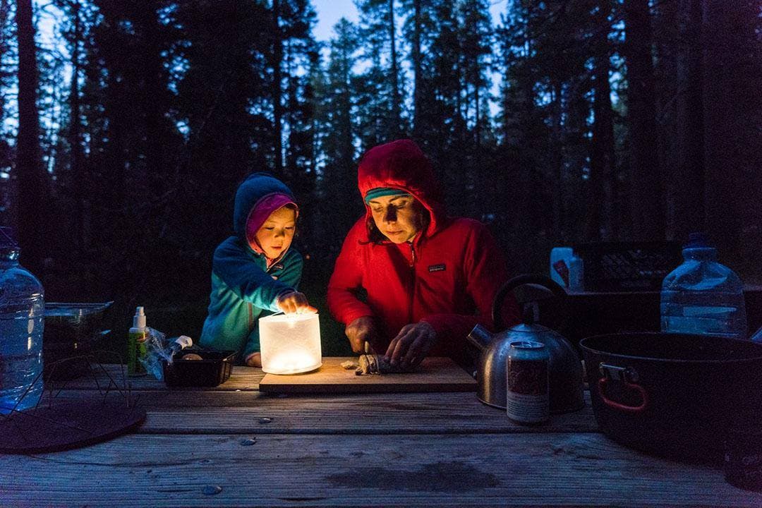 Image: Mother and child make dinner while camping