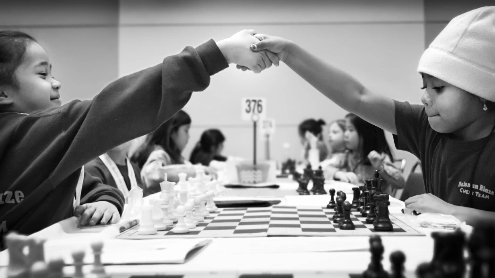 Image: Girls shaking hands over a chess game