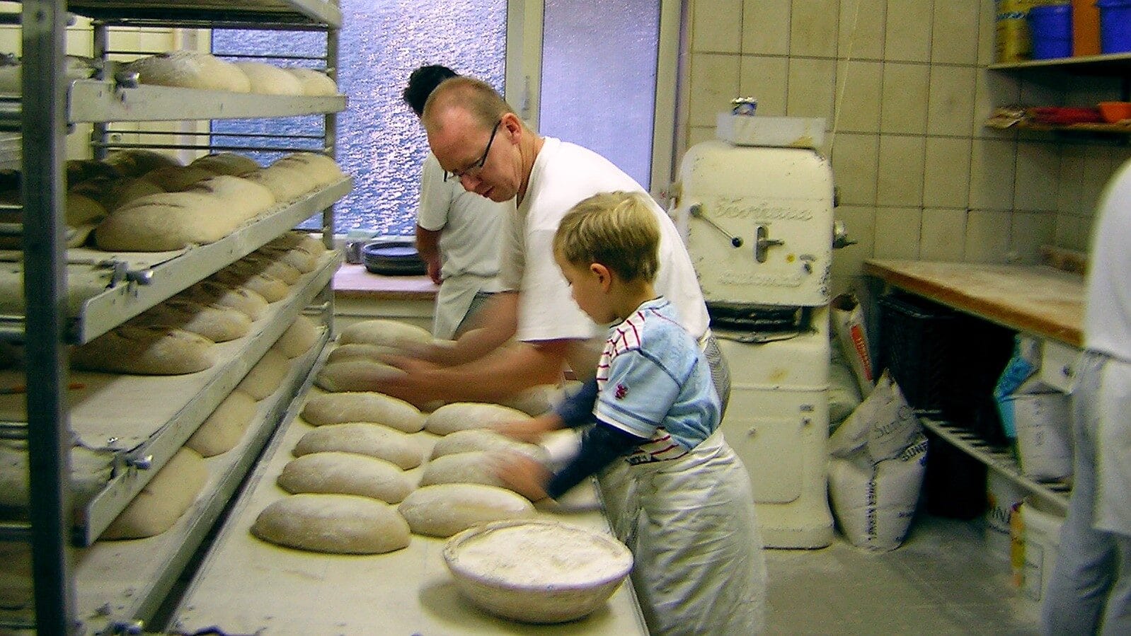 Image: man teaches a child to bake bread