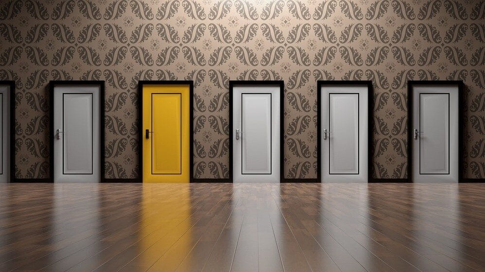 Image: 5 doors, four grey and 1 yellow, representative of making choices.