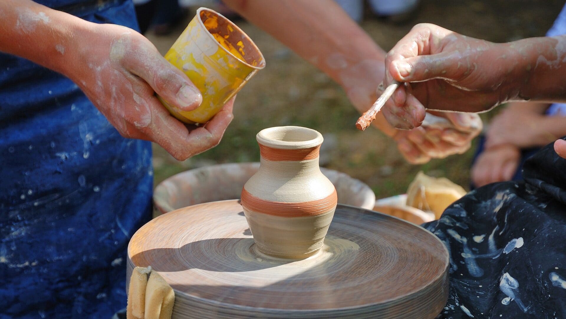 Image: People using their hands to create pottery.