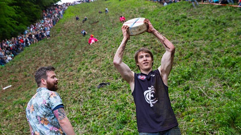 Image: Cheese Rolling Festival second race winner holding his wheel of cheese above his head