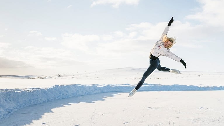 Image: Emmi Peltonen jumping in the air in the arctic rink
