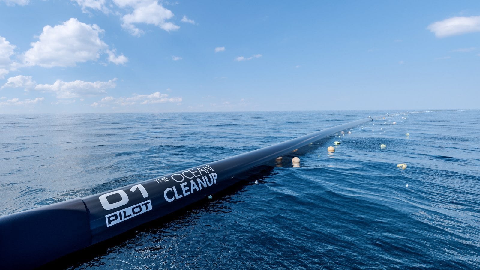 Image: Ocean Cleanup Project boom array in the ocean with collected plastic floating in it