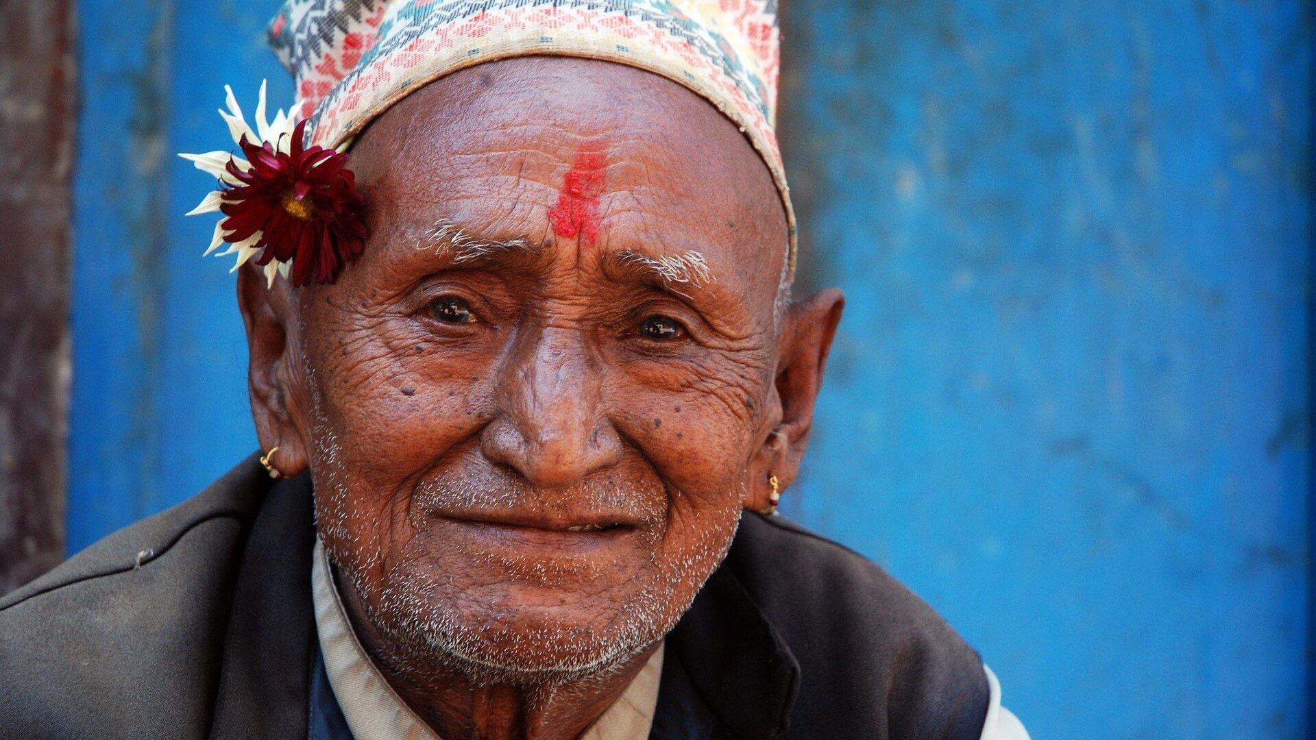 Image: Elderly man with a flower tucked behind his ear