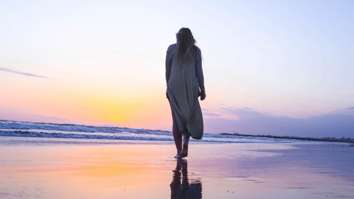 Image: woman walking on the beach at sunset, deliberate intent.