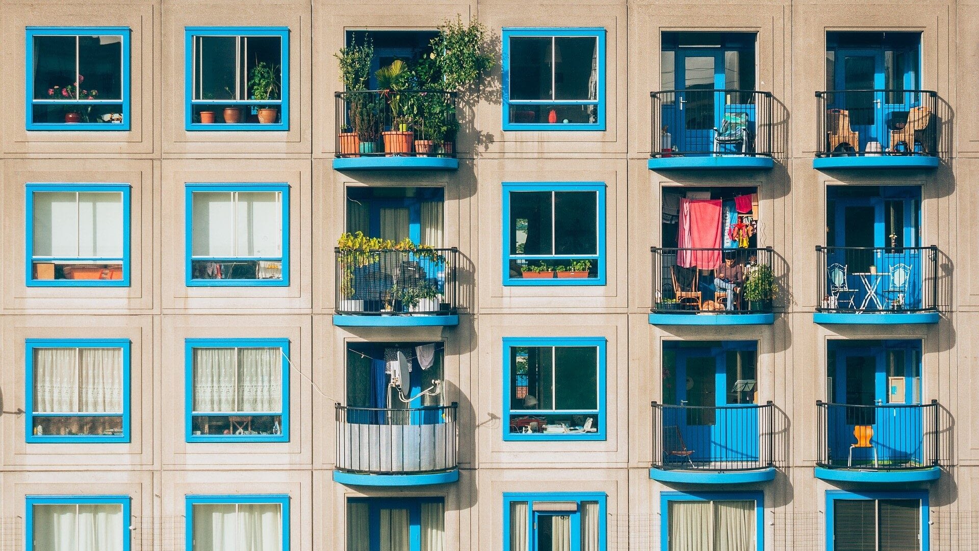 Image: side of apartment building with individual balconies showing many different versions of home