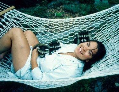 Lynda hanging with a racoon in an hammock