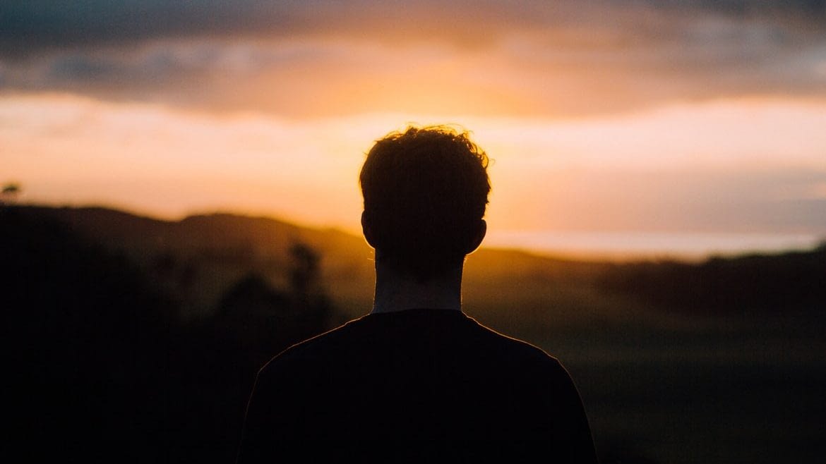 Image: Silhouette of a short haired person staring at the sunset, problems