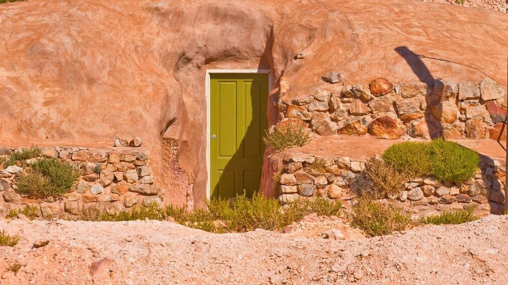 Image: Green door in the sandstone—an entrance to an underground home in Coober Pedy