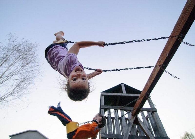 Image: Kids swinging and one upside down