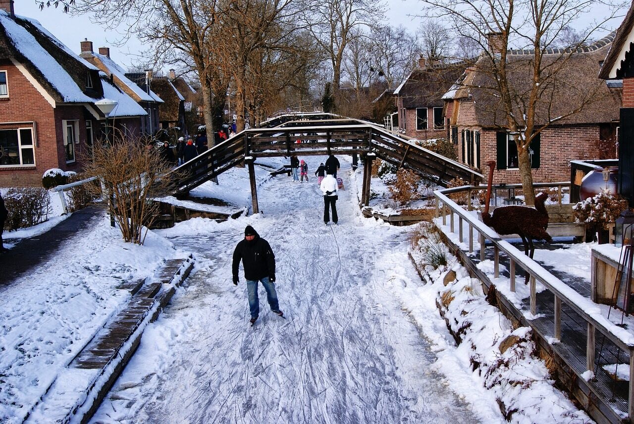 Image: People ice skating down the frozen canals in Giethoorn